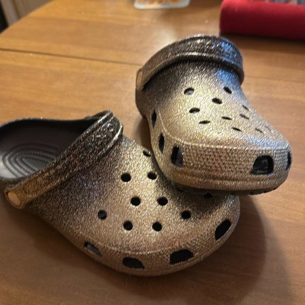 Crocs NWOT, size women 9. Gold/black sparkle ombré shoes.